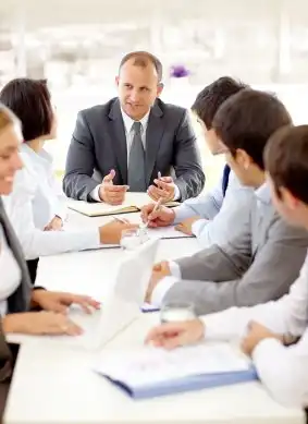 A diverse group of Employer Attorneys sitting around a conference table, engaged in a meeting  - Vision Law