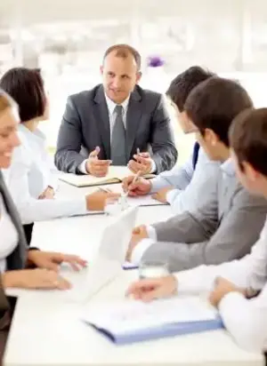 A group of professionals sitting around a table discussing free employment law consultation - Vision Law