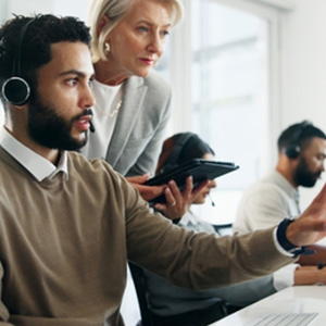 Manager supervising a call center employee, illustrating employee monitoring policy